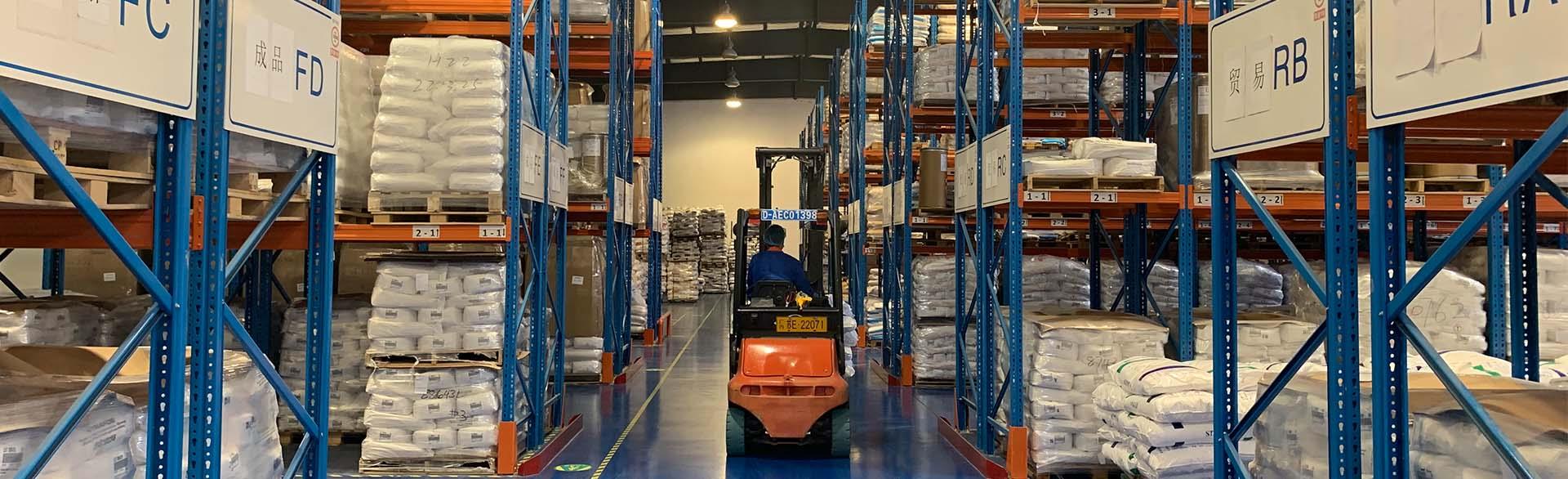 Forklift operator in a warehouse with blue shelves and labeled storage sections.